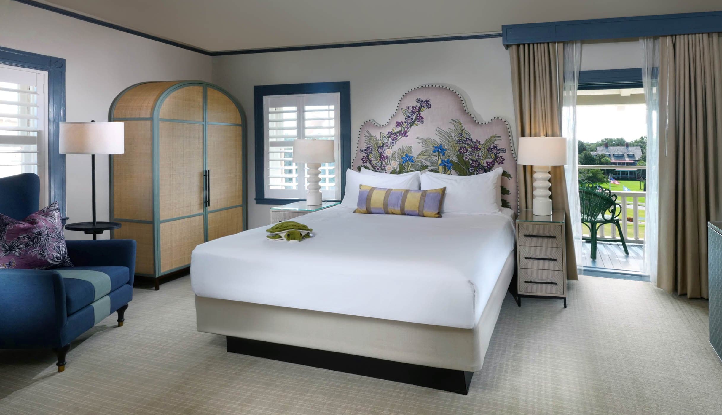 A queen bed in a room with access to a balcony