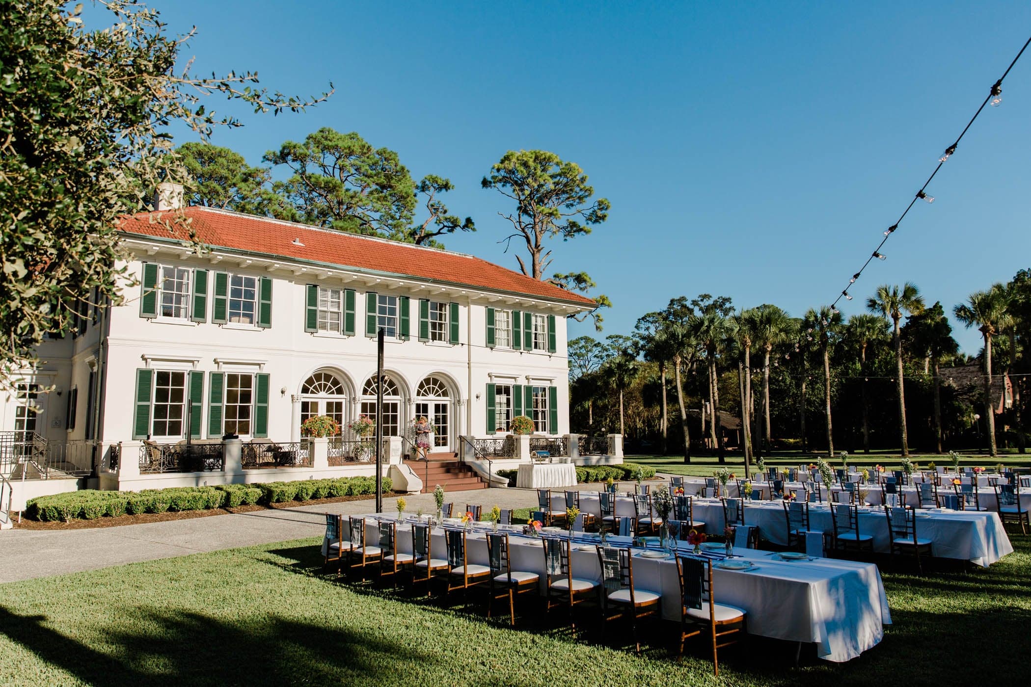 The front yard of Cherokee Cottage set up for a function with 4 long tables with place settings set up