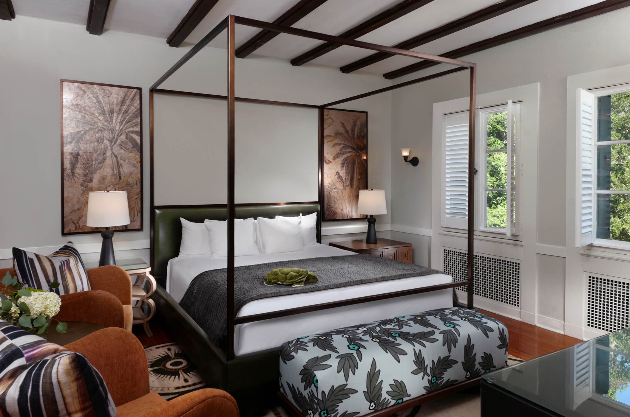 A king bed with a canopy and lounge area in a Crane Traditional King room