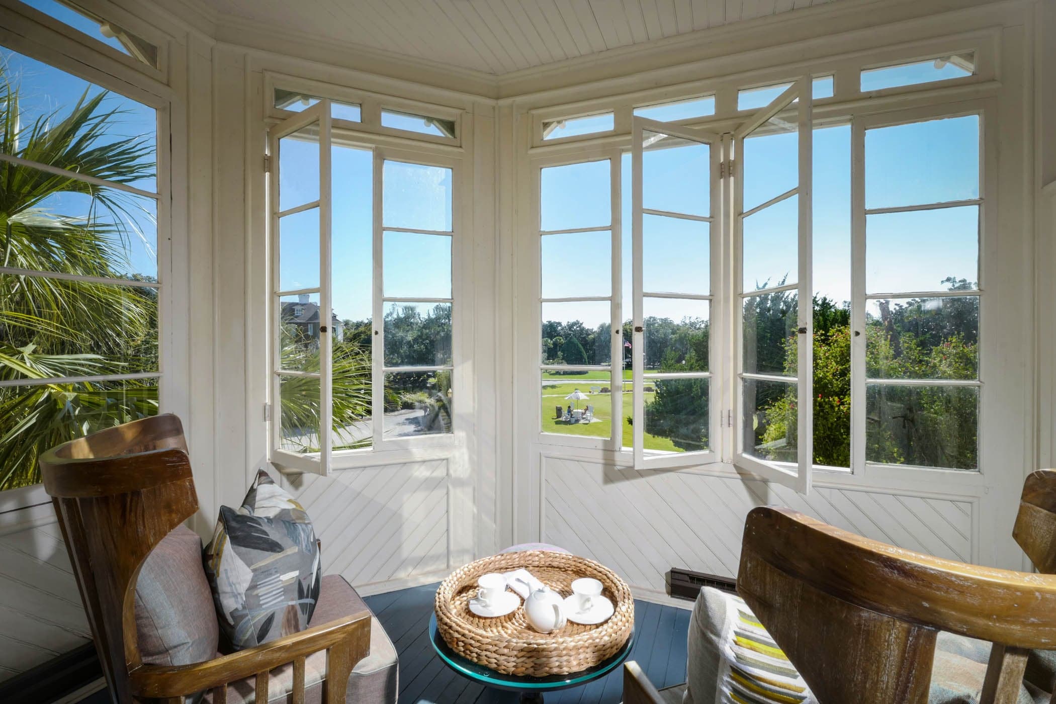 A sun room off a room with a view of the greenery surrounding the property
