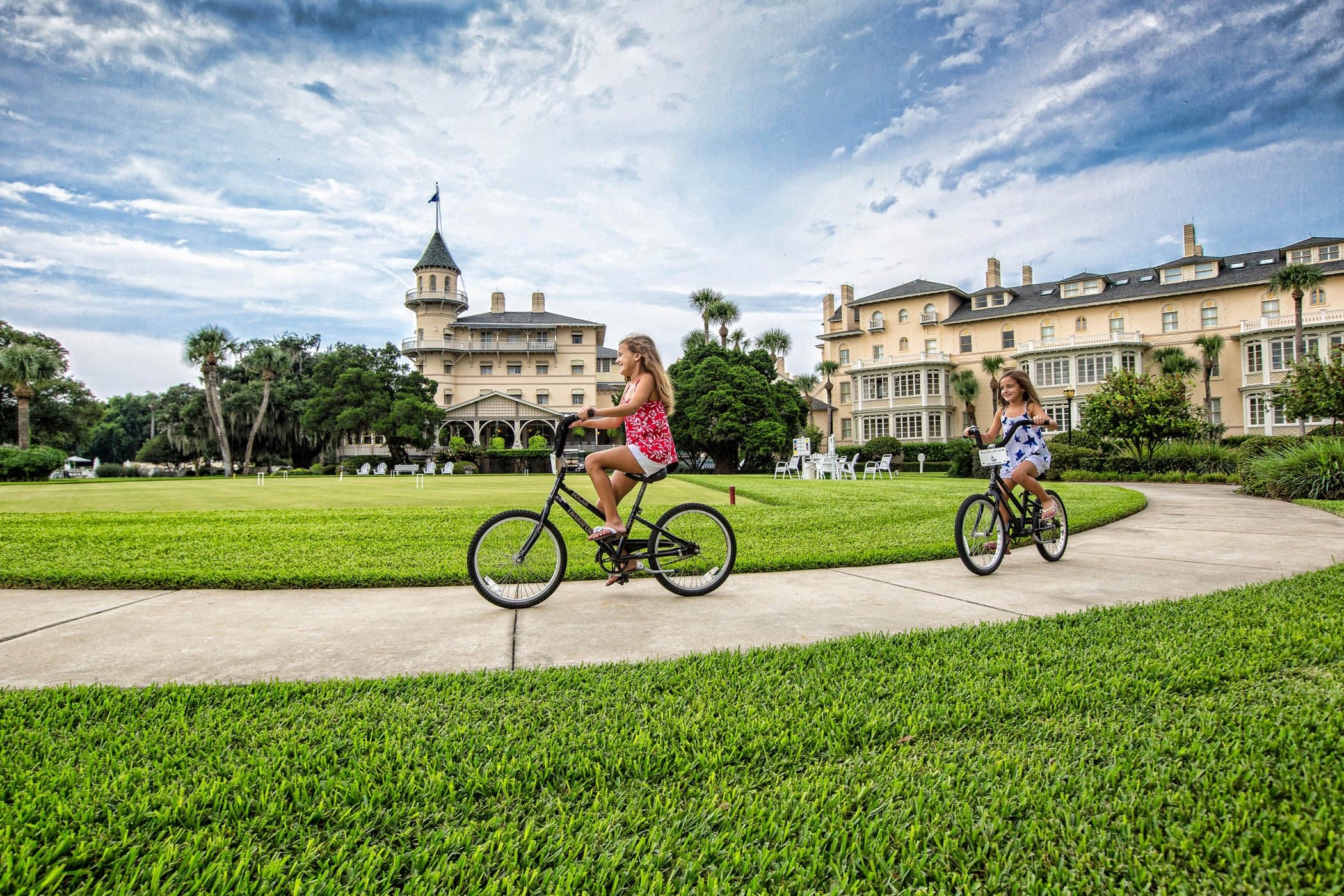 2 little girls biking on a path on a beautiful day