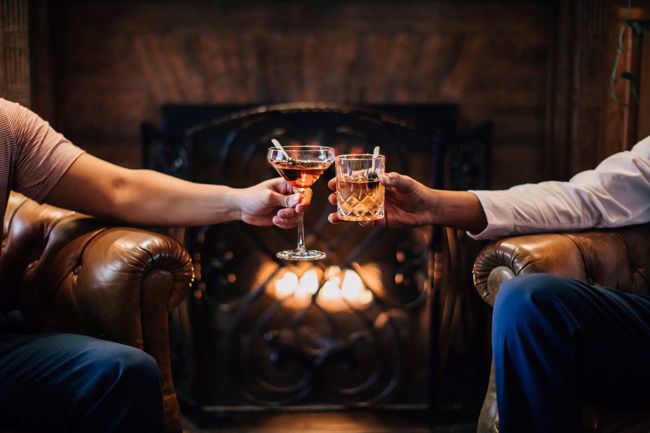 Two people cheers-ing their cocktails