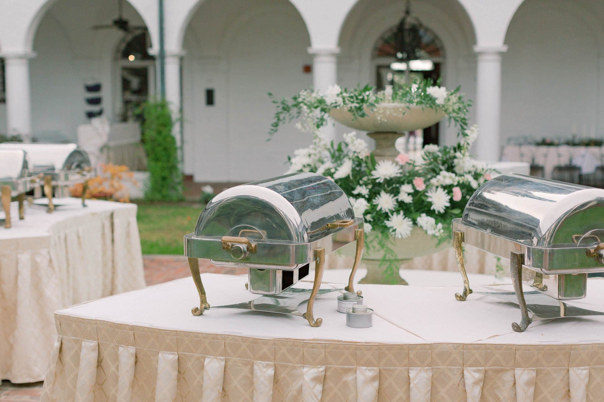 4 chaffing dishes set up at a wedding celebration on an outdoor table