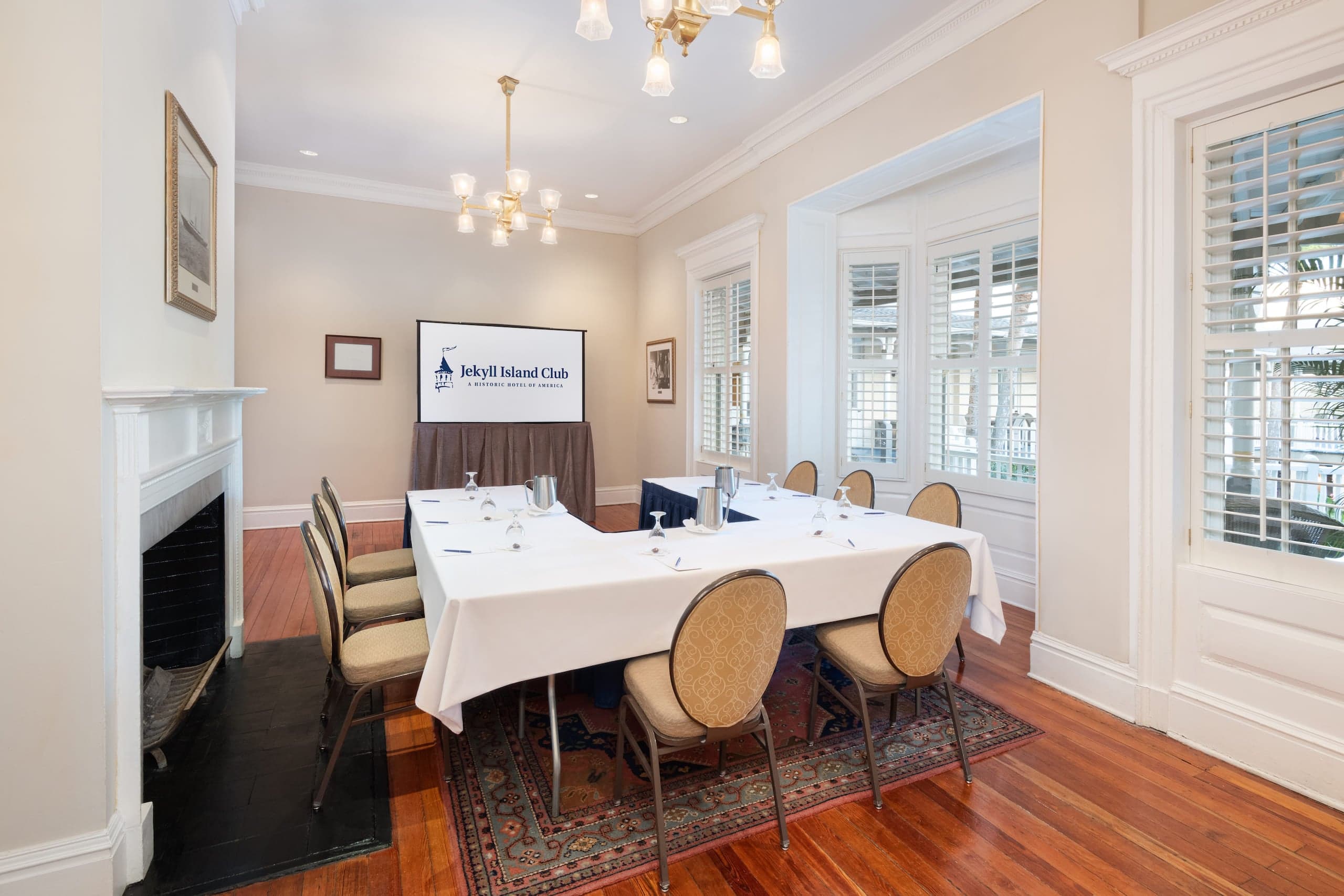 The Aldrich Room set up for a function with a horseshoe table structure and a TV set on the wall