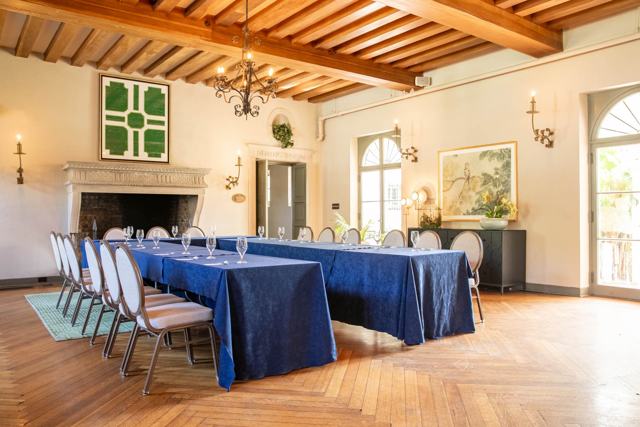 A space set up for a function with 2 long tables set with glasses and silverware