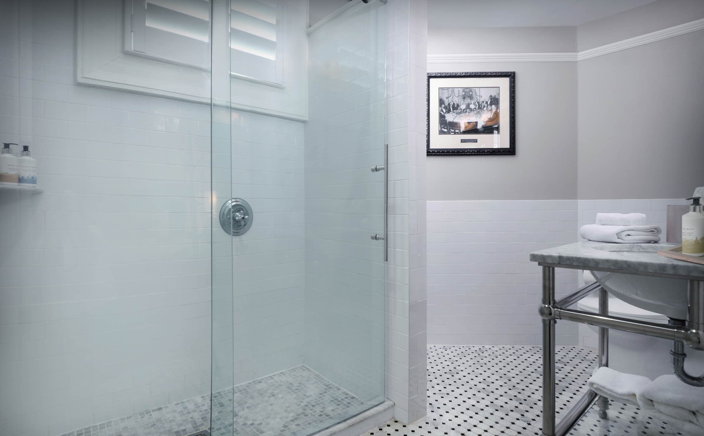 A washroom with a walk-in shower and marble top vanity