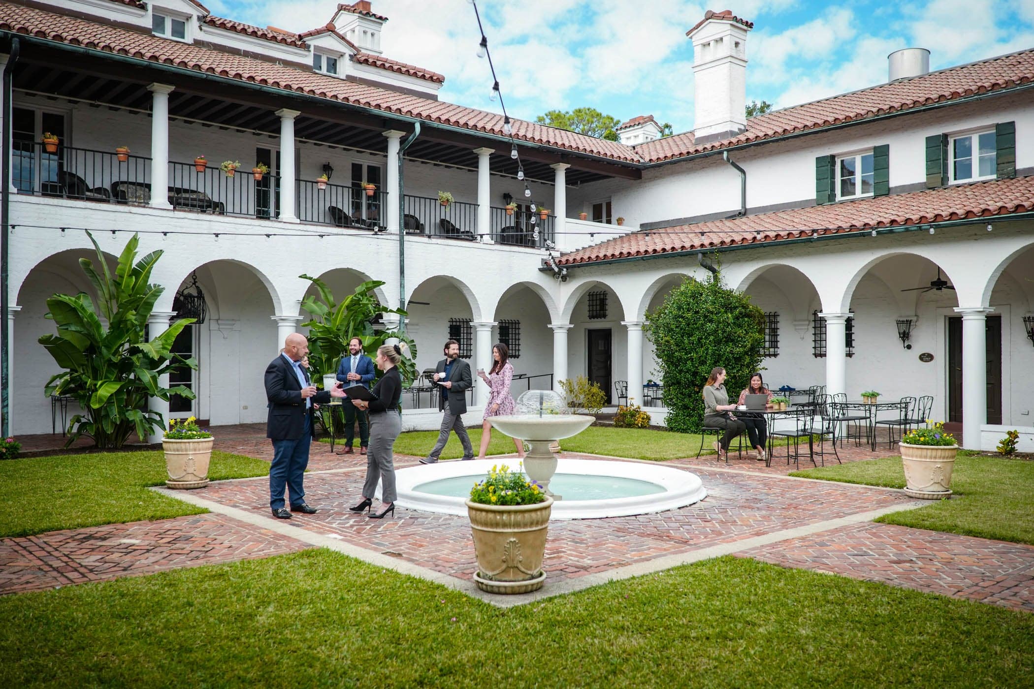 A courtyard with a fountain and people gathering