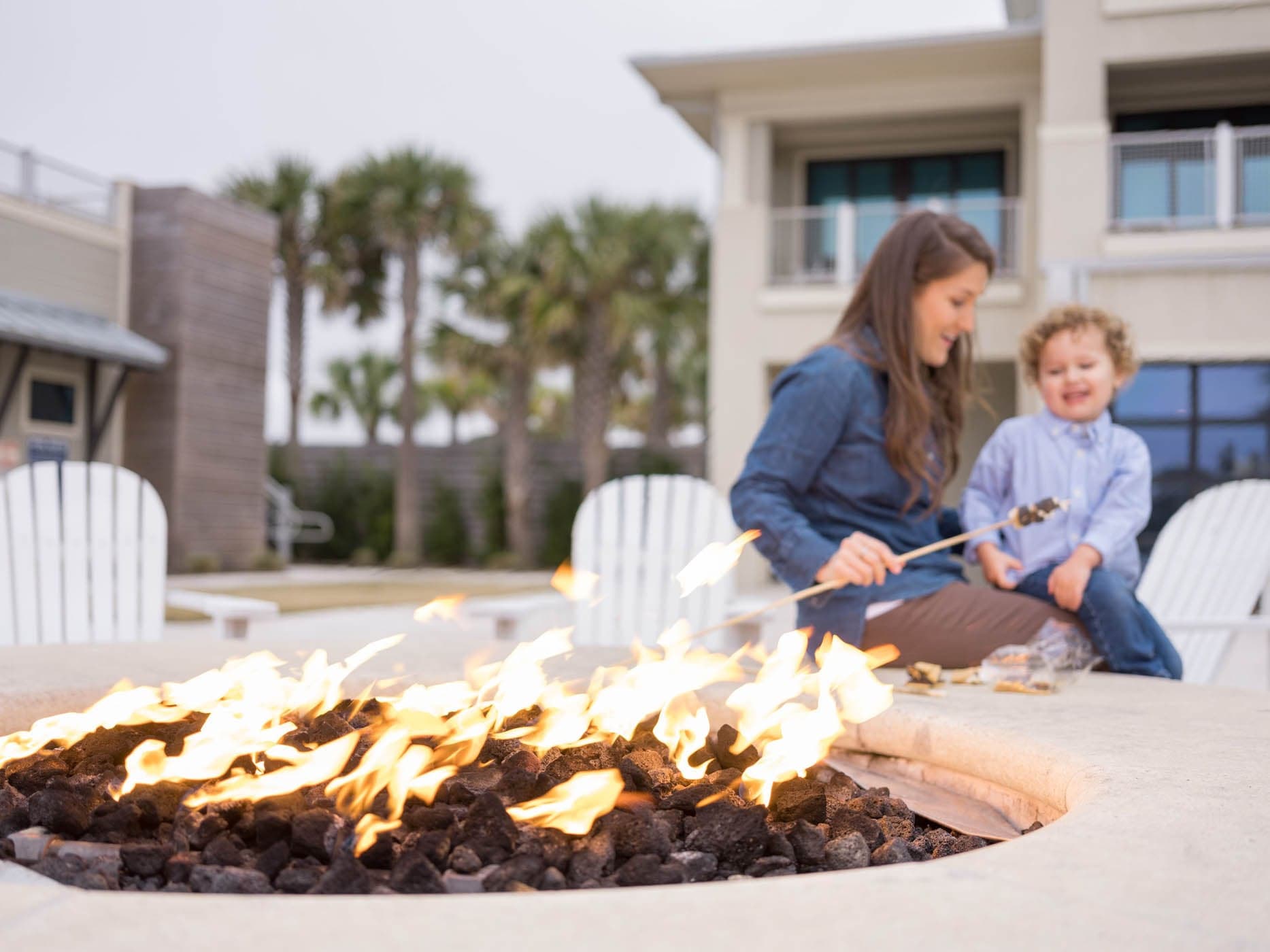 A mother and child making S'mores at the outdoor fire pit