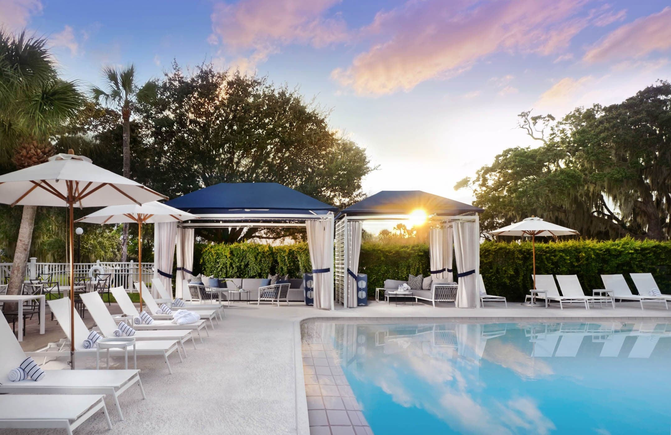 The pool area of JOC with cabanas and lounge chairs