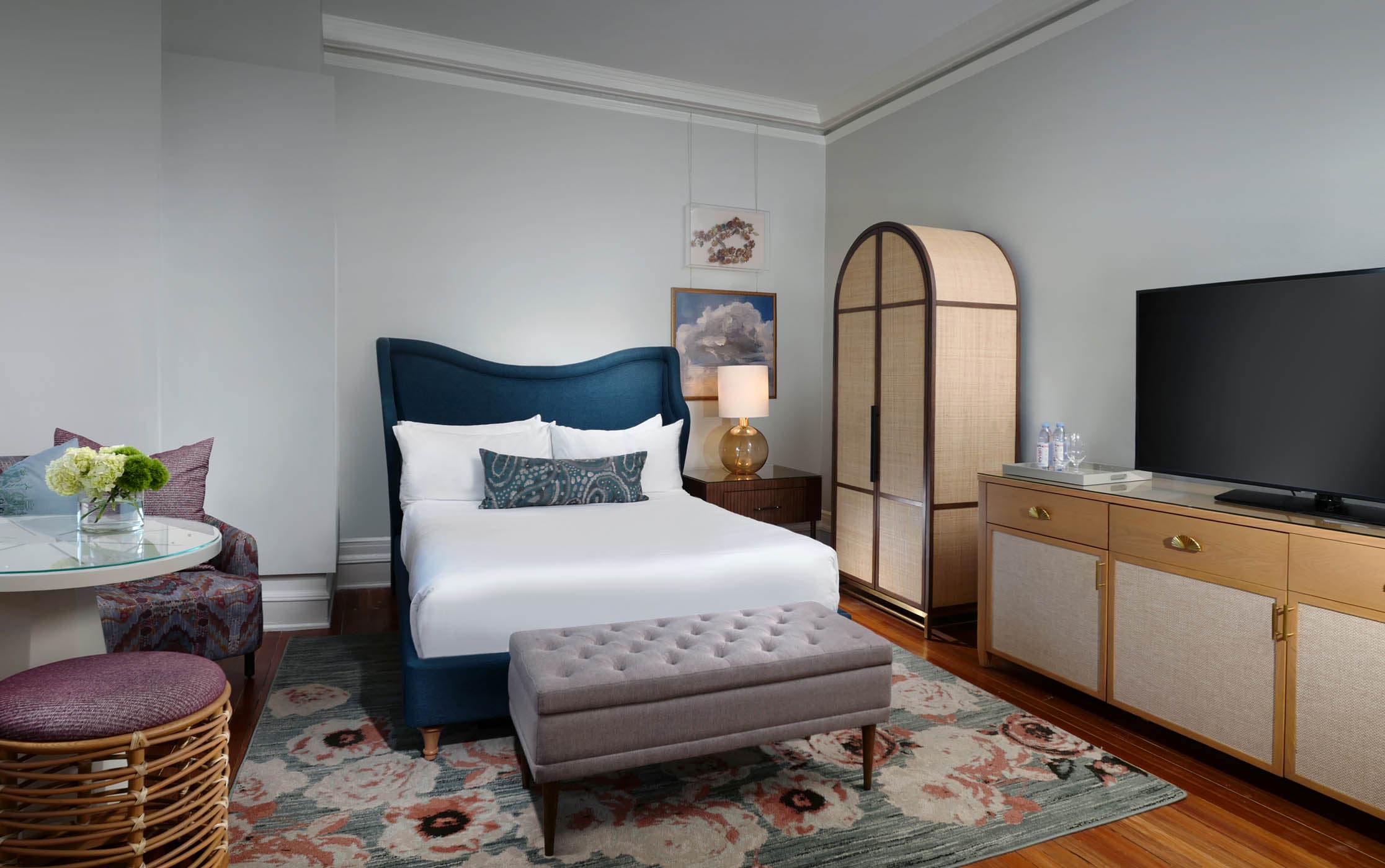 A queen bed, small table and TV in a San Souci Queen room