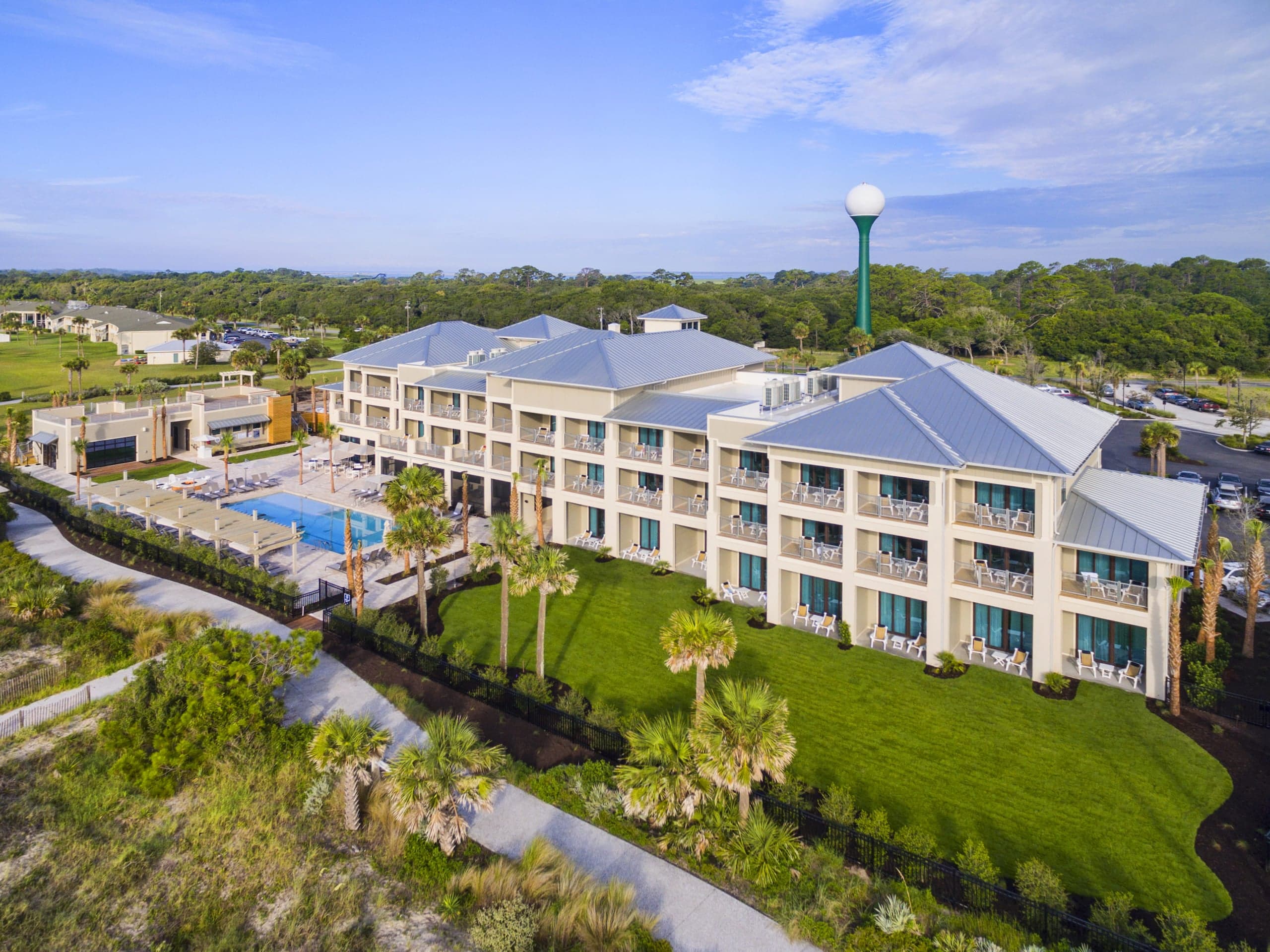The exterior of a section of the resort with the pool area and a lot of green space