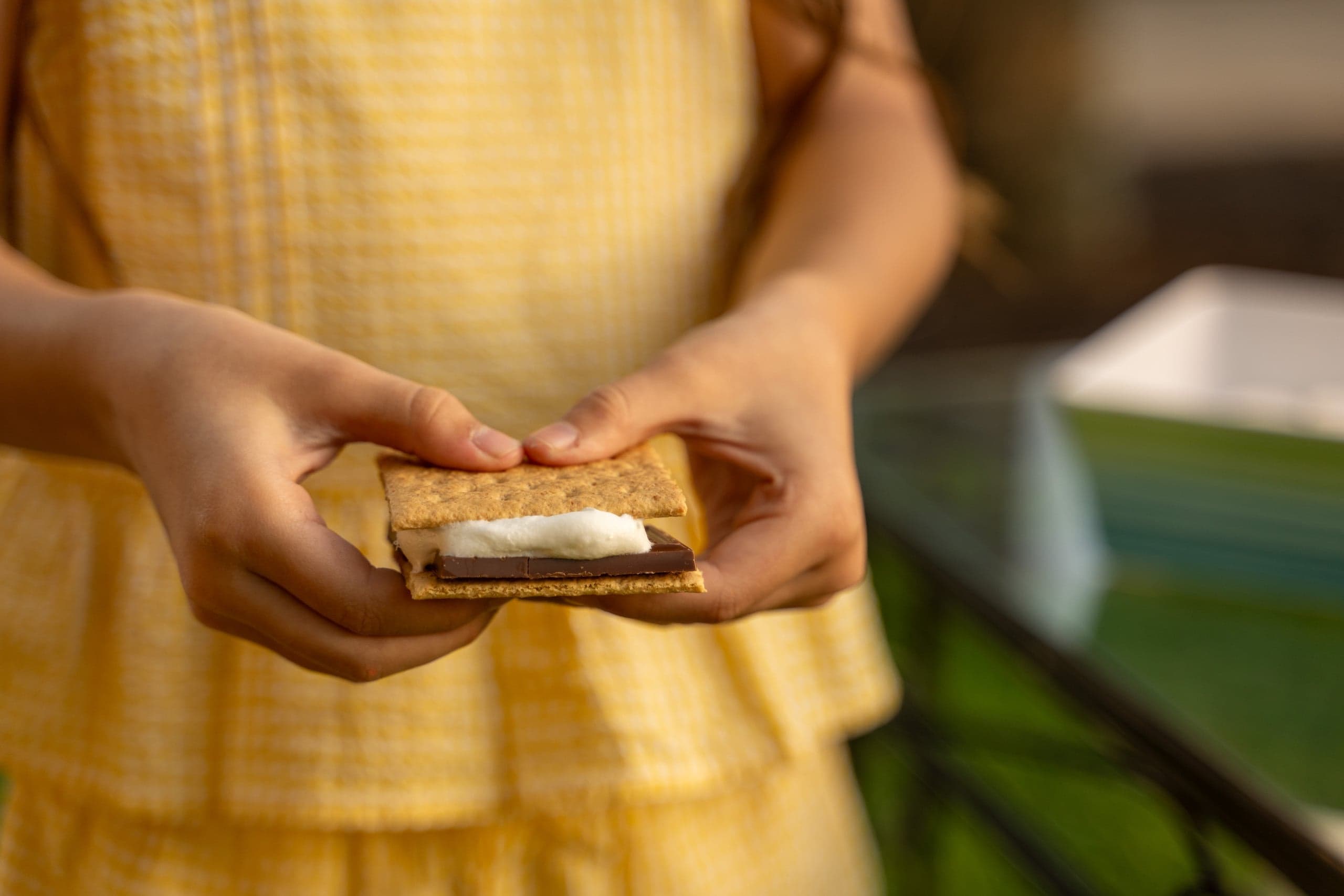 A child's hand holding a S'more