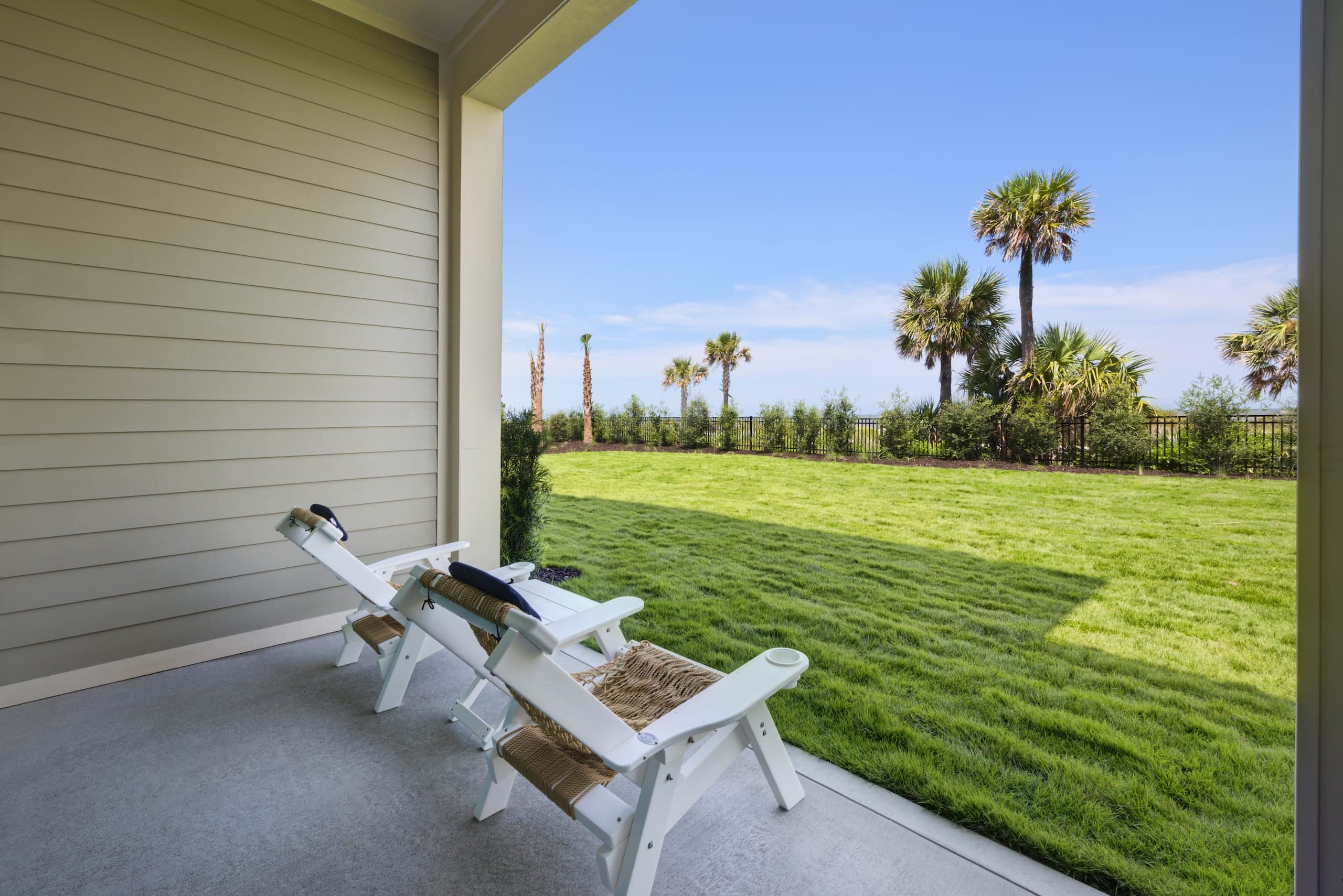 Two patio chairs facing a lawn at JOC