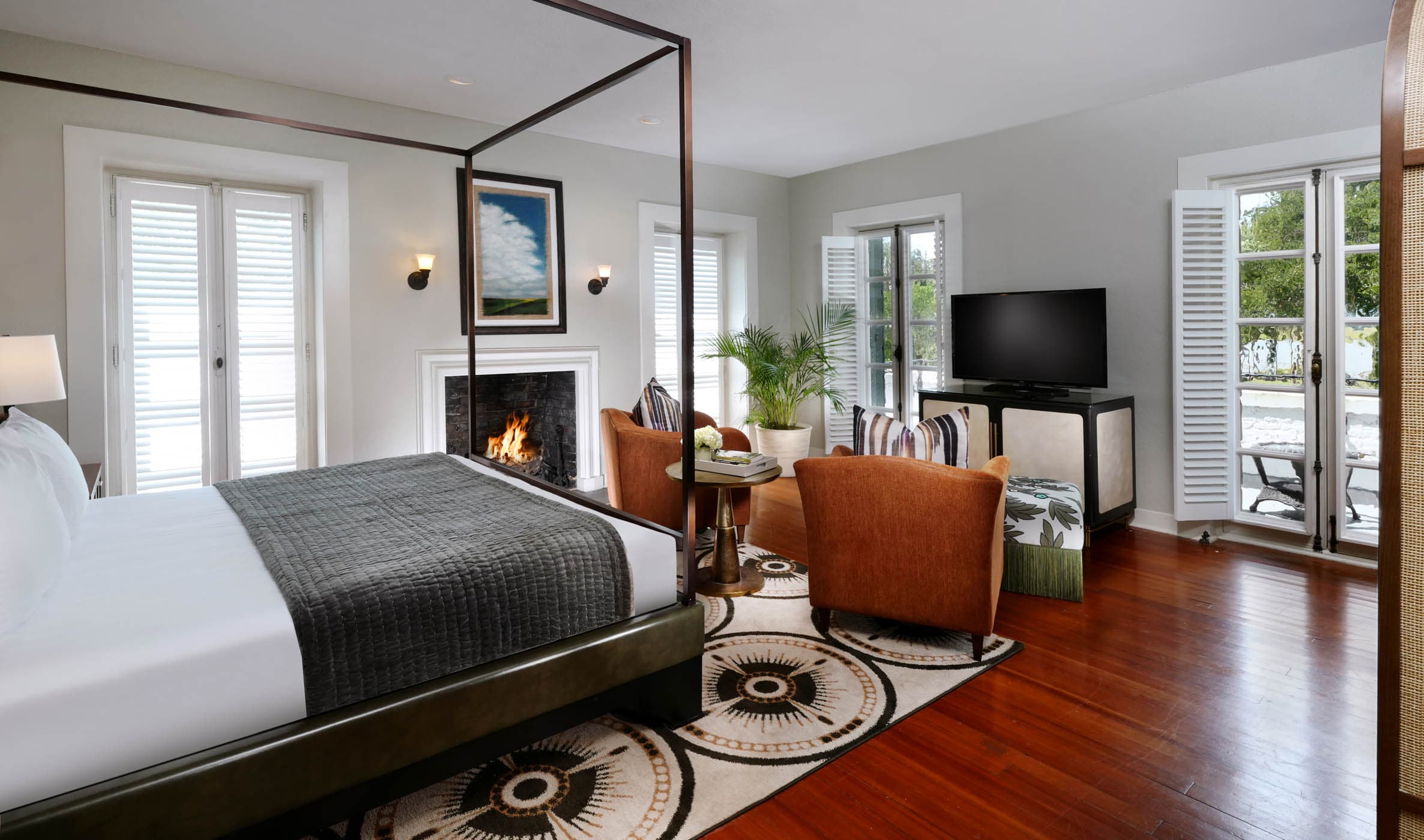 A king bed with a canopy and the living space in a Crane Deluxe King