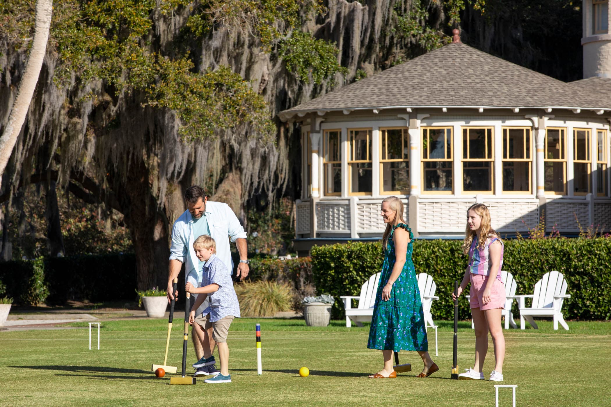 A family playing croquet out front of JICR