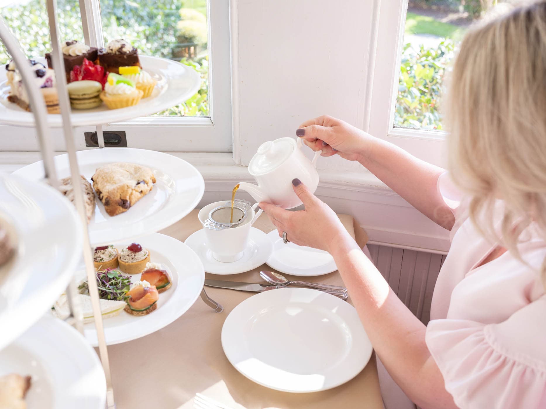A woman pouring herself tea at high noon