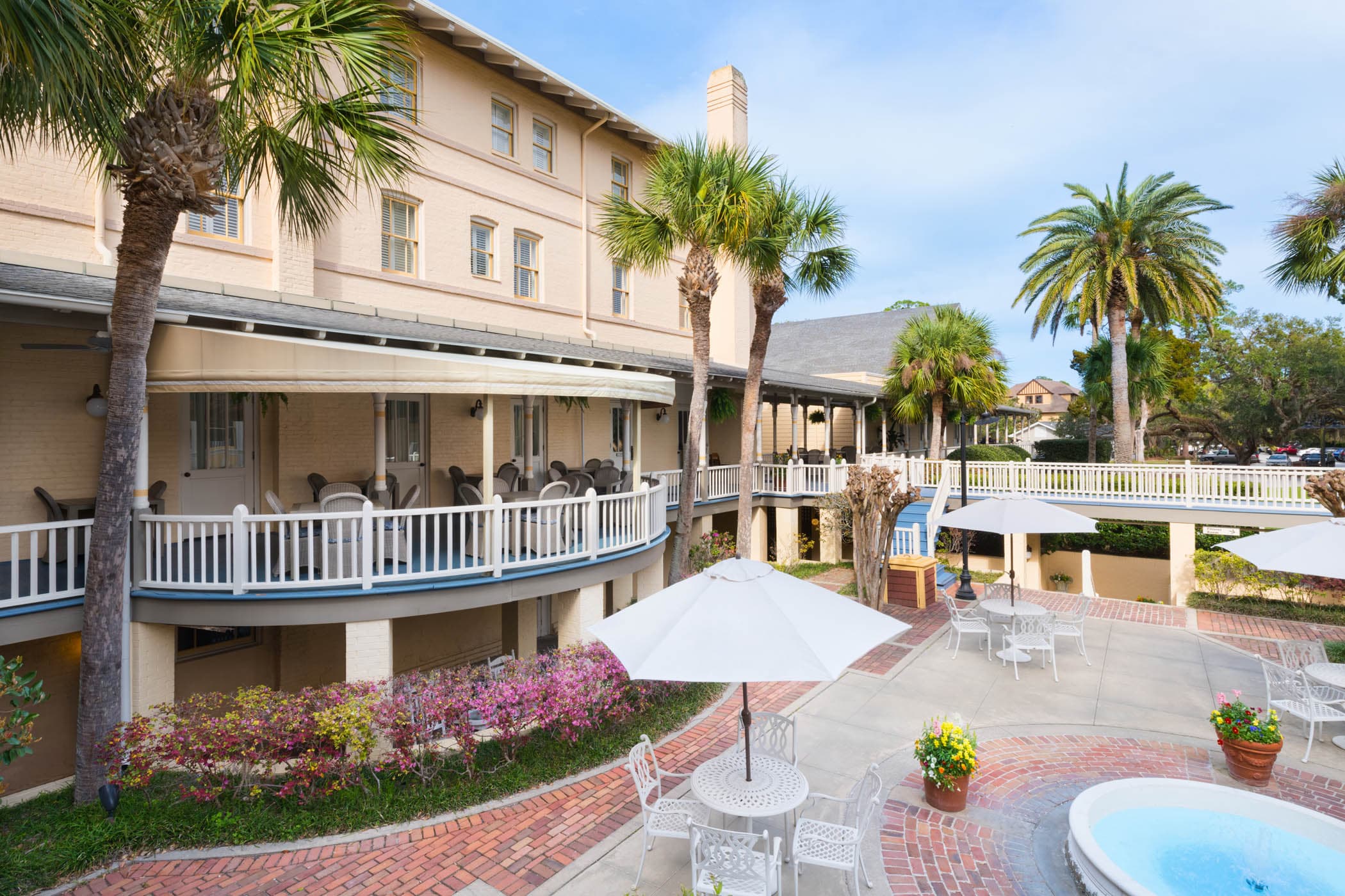The exterior of the JICR with palm trees, a fountain and the balcony patios