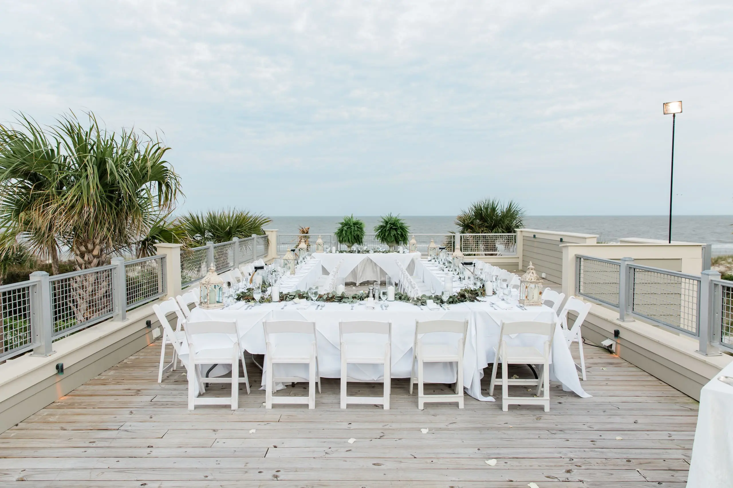 A wedding banquet table set up on a beachfront terrace