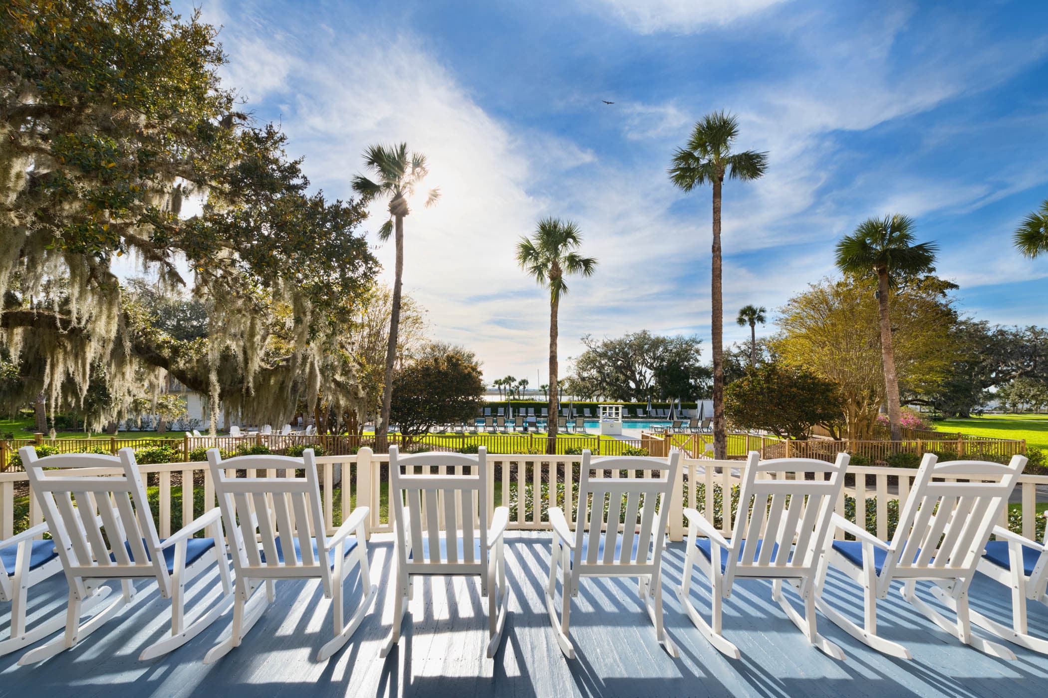 A patio area off the hotel with 6 rocking chairs