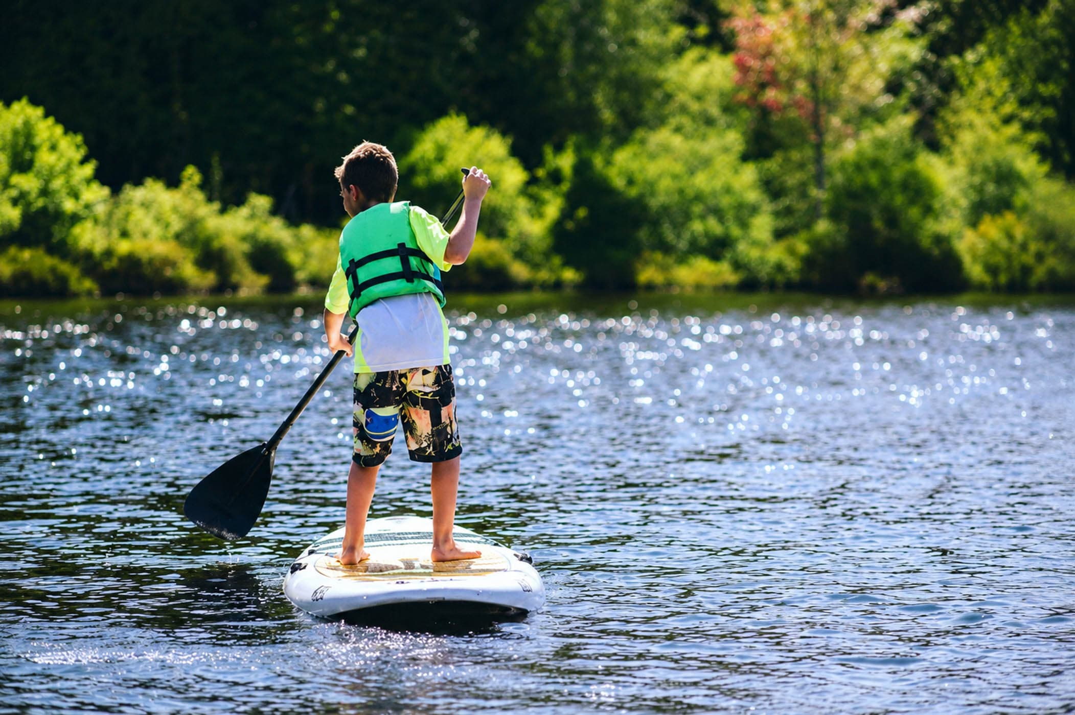 A kids paddling on a paddle board