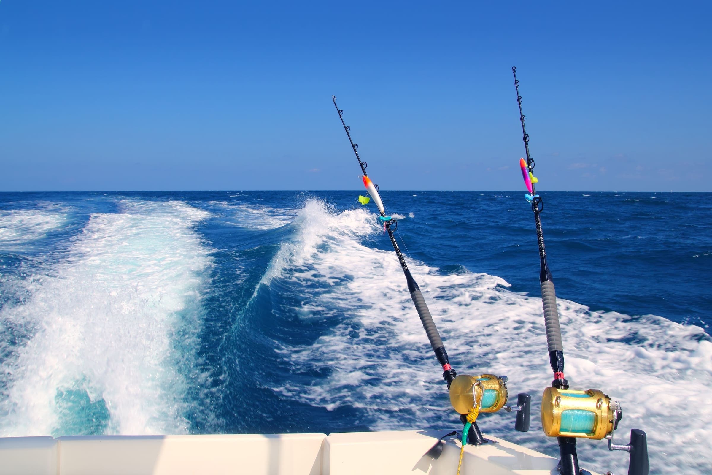 The back of a boat with 2 fishing rods attached