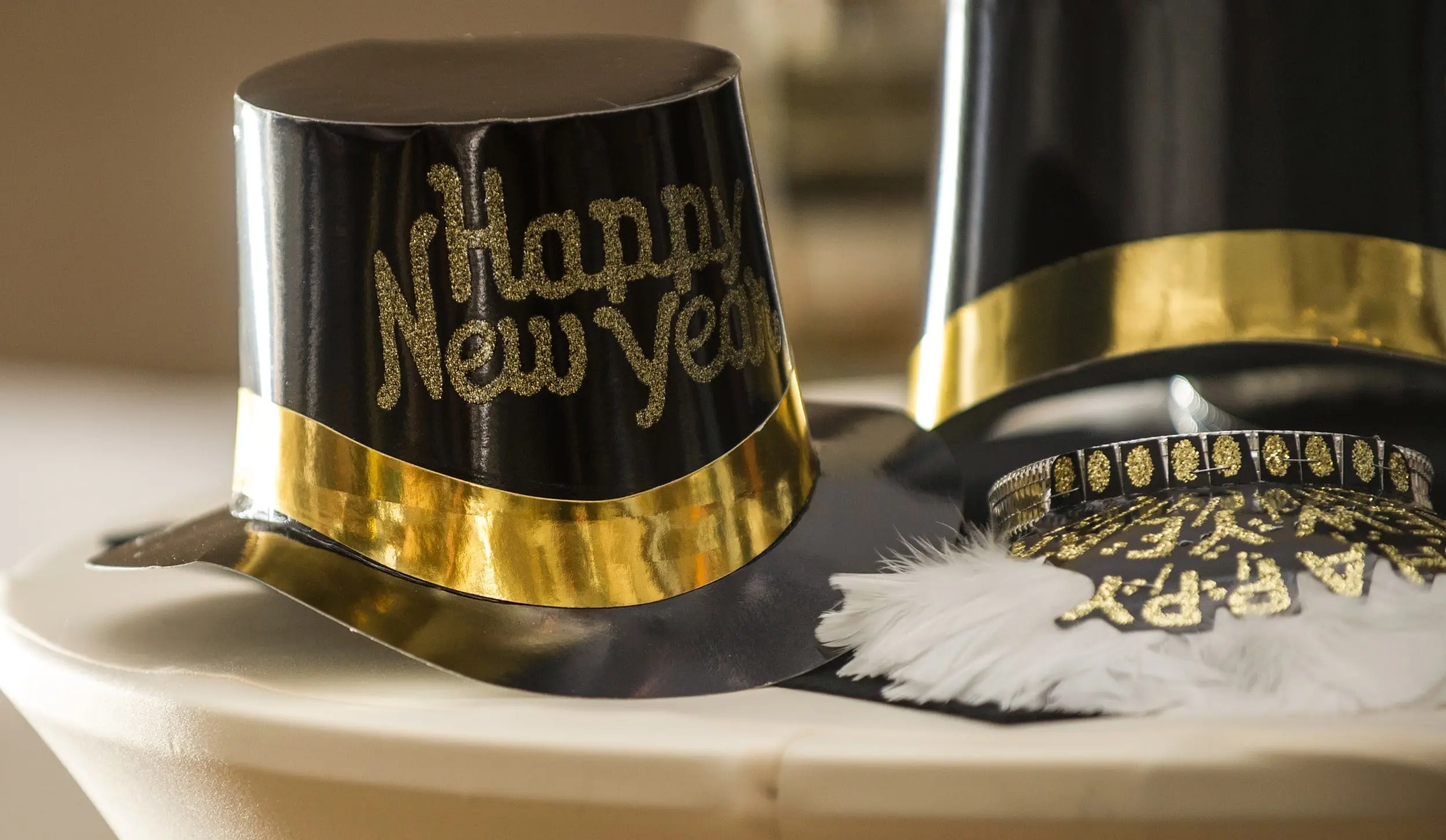 Black and gold glitter "Happy New Year" top hats and a feathered party tiara set out for a New Year's Eve celebration at Jekyll Island Club Resort in Georgia