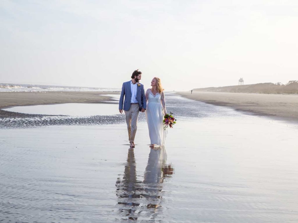 Bride And Groom Walking On The Beach.