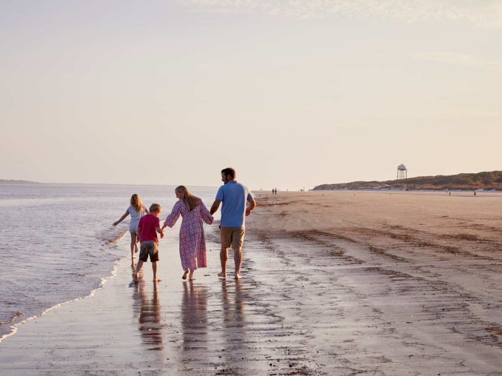 Family Walking On The Beach At Jekyll.